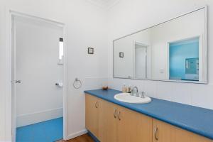 ein Badezimmer mit Waschbecken und Spiegel in der Unterkunft Beachfront Prevelly Exclusive Holiday Home in Prevelly + 21 Fotos