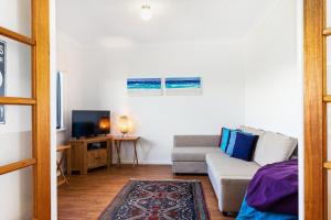ein Wohnzimmer mit Sofa und Fernseher in der Unterkunft Beachfront Prevelly Exclusive Holiday Home in Prevelly