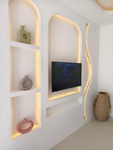 a living room with a tv and shelves at Villa in the Heart of Pererenan Prime Location in Munggu