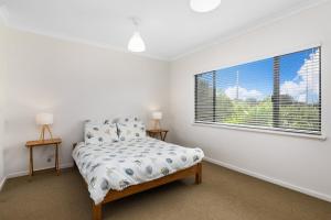ein Schlafzimmer mit einem Bett und einem Fenster in der Unterkunft Beachfront Prevelly Exclusive Holiday Home in Prevelly