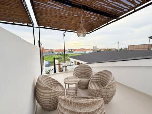 a balcony with rattan chairs and a table at Villa in the Heart of Pererenan Prime Location in Munggu