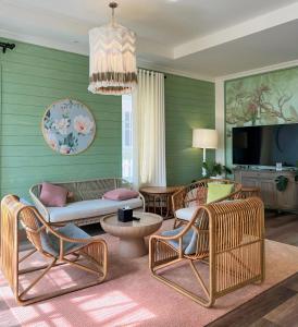 a living room with wicker chairs and a tv at Hamster Villa in Bình Tú