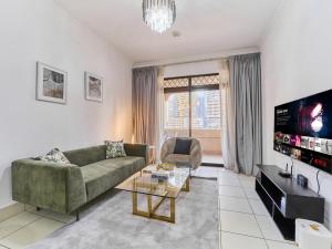 a living room with a couch and a tv at Golden Homes 1BR Reehan miniPalais Beside Burjh & Dubai mall Downtown in Dubai