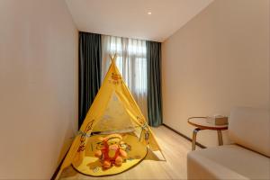 a room with a tent with a teddy bear in it at Crystal Orange Shanghai Safari Park Hotel in Shanghai