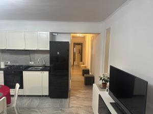 a kitchen with a black refrigerator and a living room at Central VIP in Craiova