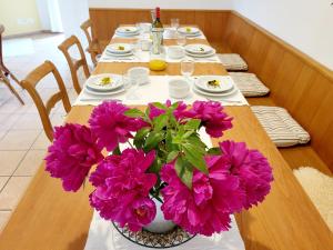a long table with purple flowers on top of it at Schöne Gartenwohnung am Strand von Tegna Centovalli in Tegna