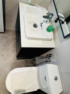 a bathroom with a white sink and a toilet at Bukit Bintang Suites KL in Kuala Lumpur