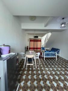 a kitchen and living room with a table and chairs at Qaseh homestay in Papar