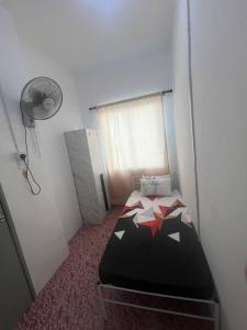 a bedroom with a bed in a room with a fan at Qaseh homestay in Papar
