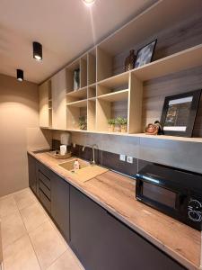a kitchen with a sink and a microwave at NAR Royalton Deluxe Apartment #74 in Niš