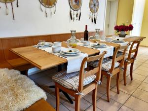 a wooden table with chairs and a bottle of wine at Schöne Gartenwohnung am Strand von Tegna Centovalli in Tegna