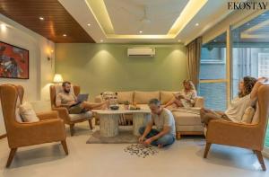 a group of people sitting in a living room at EKOSTAY - Grey Goose Villa in Calangute