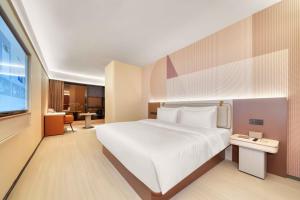 a bedroom with a large white bed and a television at Orange Hotel Hangzhou Songcheng in Hangzhou +16 photos