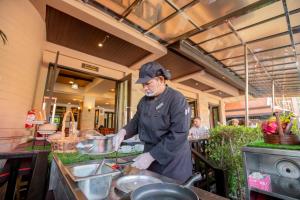 a man preparing food in a restaurant kitchen at Nipa Resort, Patong Beach in Patong Beach +141 photos