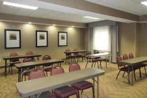 Comfort Inn Port Huron في بورت هورون: قاعة اجتماعات مع طاولات وكراسي ونافذة