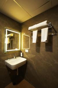 a bathroom with a sink and a mirror and towels at Veerdency Luxury Resort - 3 Km to Banglore Airport in Bangalore