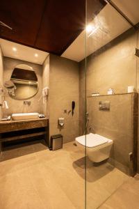 a bathroom with a toilet and a sink and a shower at Hotel Classic Pavilion in Trivandrum +9 photos