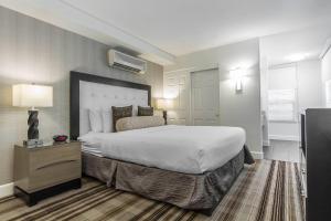 Inn Off Capitol Park, an Ascend Collection Hotel في سكرامنتو: غرفة فندقية مع سرير كبير وتلفزيون