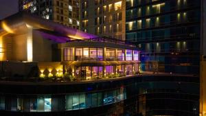 un edificio con piscina frente a un edificio alto en The Grand Platinum Jakarta, en Yakarta