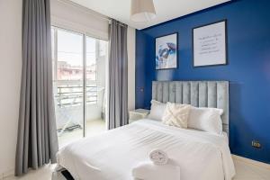 - une chambre avec des murs bleus et un lit blanc dans l'établissement TT Holidays-Rabat City Center, à Rabat