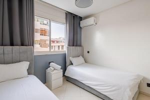 deux lits dans une petite pièce avec une fenêtre dans l'établissement TT Holidays-Rabat City Center, à Rabat