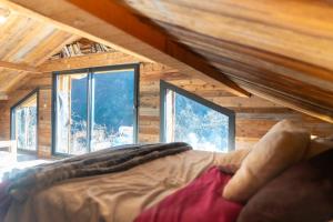 a bedroom with a bed in a room with windows at La sittelle in Belvédère