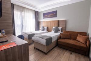 a hotel room with two beds and a chair and a desk at The Omiya Hotel in Istanbul