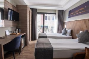a hotel room with two beds and a desk at The Omiya Hotel in Istanbul