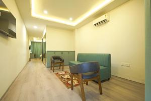 a waiting room with a green couch and chairs at Veerdency Luxury resort in Bengaluru