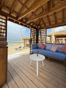 Karpaz Gate Marina Hotel في Ayia Trias: غرفة معيشة مع أريكة زرقاء وطاولة