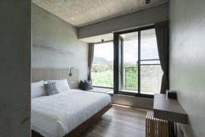 a bedroom with a bed and a large window at Mr,M都蘭 in Taitung City