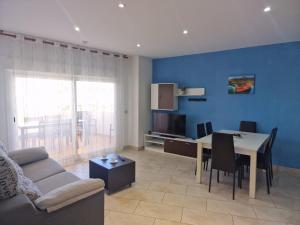 Apartamentos Cala Azul La Móra في تاراغونا: غرفة معيشة مع أريكة وطاولة طعام