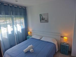 Apartamentos Cala Azul La Móra في تاراغونا: غرفة نوم بسرير ازرق وعليها منشفة بيضاء +144 صورة