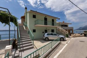 a white car parked in front of a house at View Blue Apartments in Brela