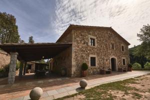 un gran edificio de piedra con techo en Villa - Can Salarichs, en Riudarenes