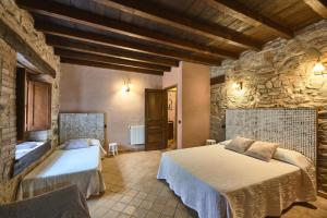 Un dormitorio con dos camas y una pared de piedra. en Villa - Can Salarichs, en Riudarenes 24 fotos más