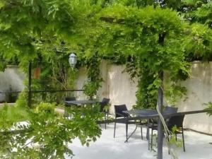 a group of tables and chairs under a tree at Belgrad Rustaveli Kobuleti in K'obulet'i