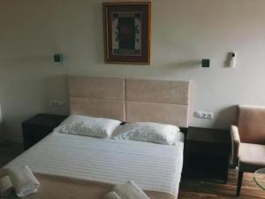 a bedroom with a white bed with a picture on the wall at Belgrad Rustaveli Kobuleti in K'obulet'i
