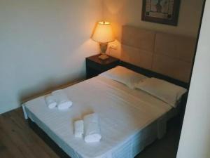 a bedroom with a white bed with towels on it at Belgrad Rustaveli Kobuleti in K'obulet'i
