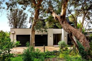 a white house with trees in front of it at Bali Hi Walk to Beach in Balnarring Beach