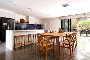 an open kitchen with a wooden table and chairs at Bali Hi Walk to Beach in Balnarring Beach