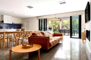 a living room with a couch and a table at Bali Hi Walk to Beach in Balnarring Beach