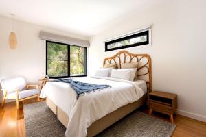 a bedroom with a large bed and two windows at Bali Hi Walk to Beach in Balnarring Beach