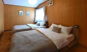 a bedroom with two beds and a window at HOSHIYA Kamifurano in Kami-furano +36 photos