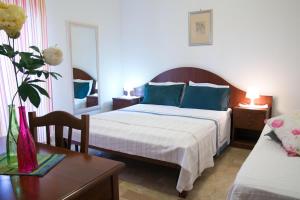 ein Schlafzimmer mit einem Bett mit blauen Kissen und einem Tisch in der Unterkunft Residenza Giancesare Family Apartments in Paestum + 112 Fotos