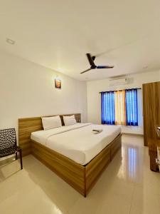 a bedroom with a bed and a ceiling fan at Staymax Parassinikadavu in Parassinikadavu