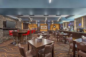 a restaurant with tables and chairs and a bar at Best Western Bonnyville Inn & Suites in Bonnyville