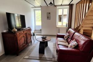 a living room with a couch and a flat screen tv at Gîte Le repos du voyageur in Mary