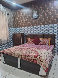 een slaapkamer met een bed met een rood dekbed bij Nidhi dham inn in Vrindāvan