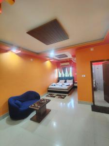 una sala de estar con un sofá y una mesa en Hotel Saksham, en Pākaur